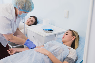 Nurse connecting an intravenous drip in hospital room.