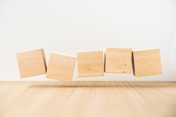 Business concept - Abstract geometric real floating wooden cube on grey background and it's not 3D render, float on wood floor white background for display or montage word.