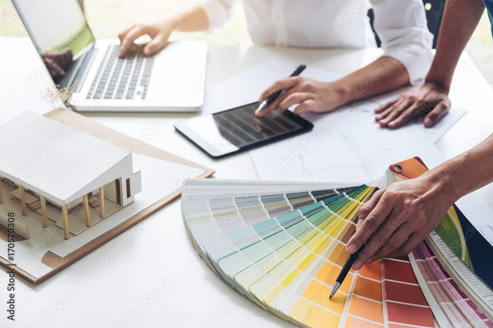 Poster Two interior design or graphic designer at work on project of architecture drawing with work tools and color swatches, colour chart, color samples for selection, renovation and technology concept
