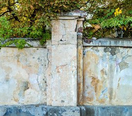 Old brick fence with cracked multi-colored plaster. Grunge textured background