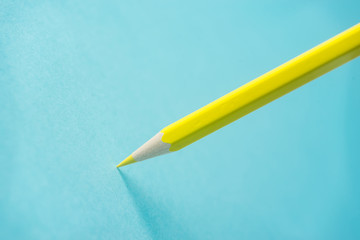 Business concept - one yellow color pencil stand on blue paper background. It's symbol of key point and confident.