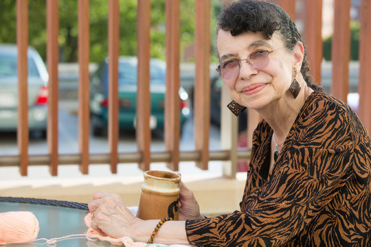 Closeup side view profile portrait, grandmother enjoying cup of drink, isolated outdoors background - Powered by Adobe