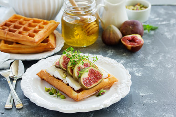 Wafers with figs, brie cheese and honey. Delicious wholesome breakfast.