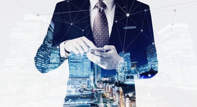 Business concept for information, communication, connection technology - double exposure effect of office man and panoramic modern city skyline bird eye aerial night view under dramatic dark blue sky