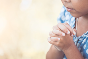Cute asian little child girl praying with folded her hand for faith,spirituality and religion concept