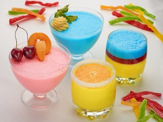 Different coloured dessert with fruit in glass