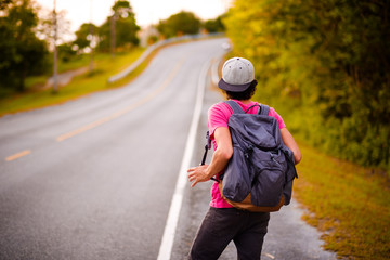 Fototapeta premium man traveling walking with backpack at national park in the jungle day time sun shine on holiday at weekend relax fresh on background nature view