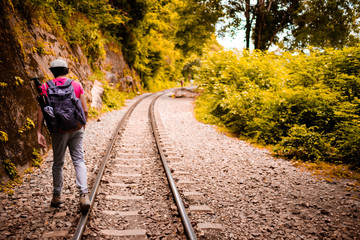Fototapeta premium man traveling walking with backpack at national park in the jungle day time sun shine on holiday at weekend relax fresh on background nature view