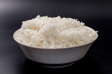 cooked rice on bowl on black background