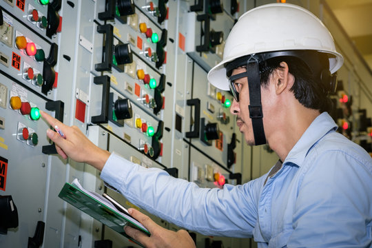 industrial technician check current status in control panel of power plant.