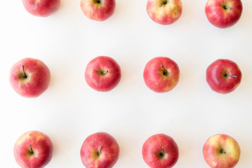 High angle view of organic pink lady apples arranged in rows on white background