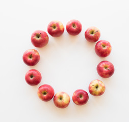 High angle view of organic pink lady apples arranged in a circle on white background with copy space