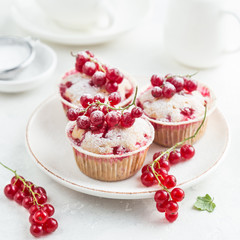 red currant muffins with fresh berries and powdered sugar