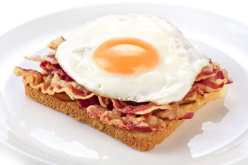 Sandwich with bacon and fried egg on a plate.