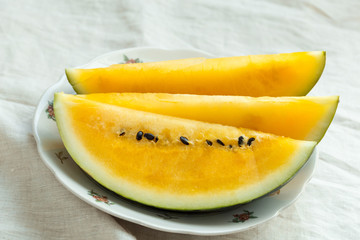 Yellow watermelon sliced on wooden background