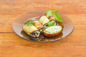 Stuffed eggplant rolls and sandwich on glass dish