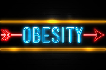 Obesity  - fluorescent Neon Sign on brickwall Front view