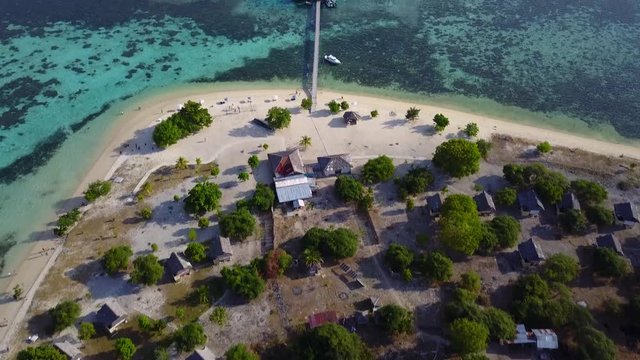 Beautiful aerial view footage of Kanawa Island resort with bungalows, wooden jetty, boats, and turquoise water. Shot in 4k resolution