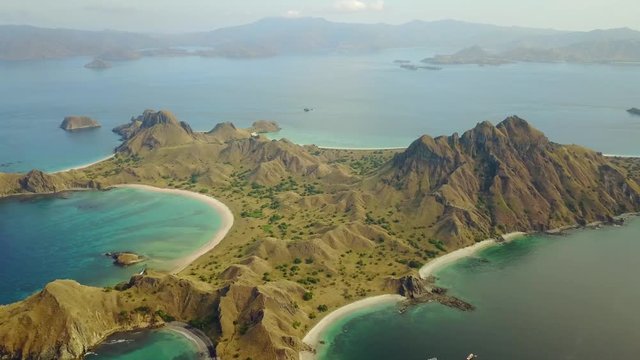 Beautiful aerial view footage of Padar Island with white sand beach, turquoise sea water, and savanna hills at East Nusa Tenggara, Indonesia. Shot in 4k resolution