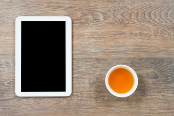 office table with tablet computer and tea cup, home working advantage concept