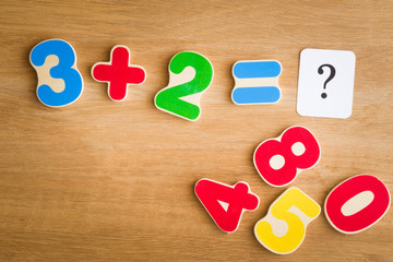 Learning numbers for little kids on the wooden table. Playing time with numbers. Education concept. Top view. 