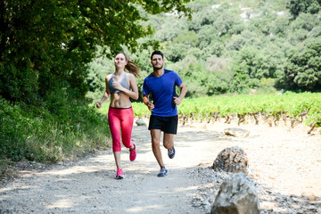 Fototapeta premium beautiful young couple running sport fitness exercising together outdoor countryside forest