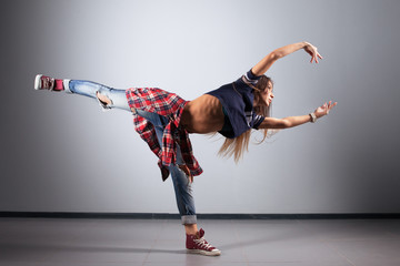 modern young beautiful dancer posing on a studio background