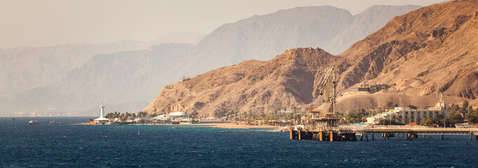 Industrial port of Eilat, Israel marine observatory and aquarium with landscape background. /...