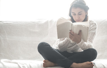 Obraz premium girl reading book on sofa
