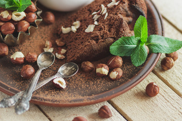 Piece of chocolate cake, mint leaves, hazelnuts and jar with milk