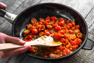 Chef cooking food for italian cuisine, tomato sauce for pasta, mediterranean diet concpet, detailed view of hands and pan with fried tomatoes