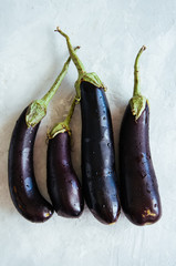 Four eggplants on a white stone background. Top view.