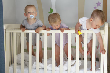 triplets in crib, triplets baby Two boys and a girl - together