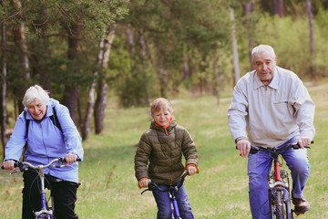 active seniors with grandson riding bikes in nature