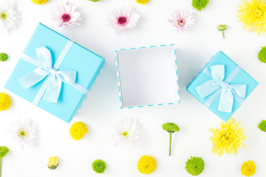 Open blue gift box with different chrysanthemums on white background