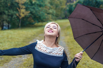 Beautiful girl with umbrella at autumn park
