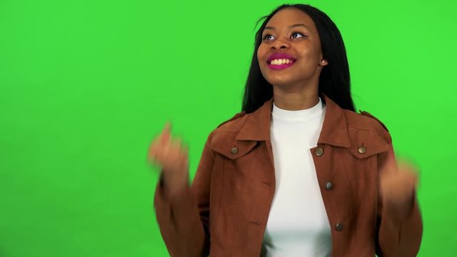 A young black woman celebrates - green screen studio