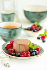 Delicious home-made chocolate dessert Panna cotta. Cream-caramel, caramel custard, with raspberries and blueberries.
