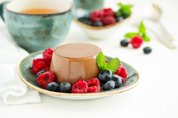 Delicious home-made chocolate dessert Panna cotta. Cream-caramel, caramel custard, with raspberries and blueberries.