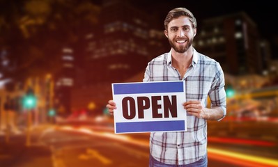 Composite image of portrait of male owner holding open sign