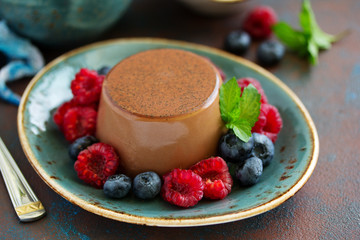 Delicious home-made chocolate dessert Panna cotta. Cream-caramel, caramel custard, with raspberries and blueberries.