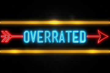 Overrated  - fluorescent Neon Sign on brickwall Front view - obrazy, fototapety, plakaty