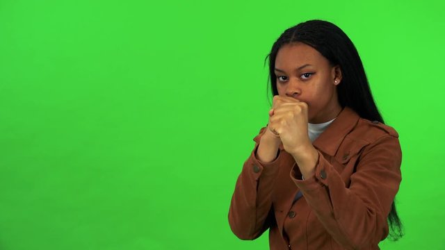 A young black woman does box - green screen