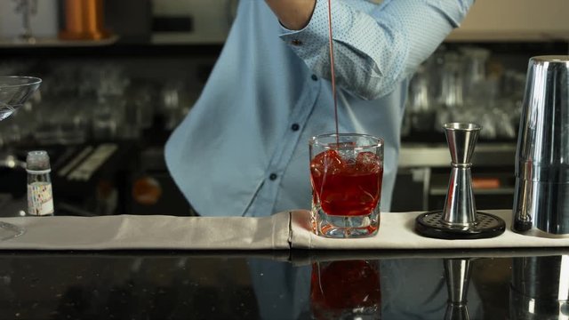 Barman preparing a cocktail in luxury bar interior. close-up
