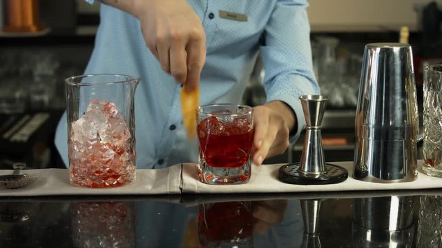 Barman preparing a cocktail in luxury bar interior. close-up