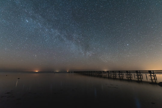 Milky way over water with a Pier