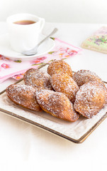 Served breakfast with French Madeleine cookies and tea in a white cup. Vertical banner