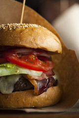 big fresh meaty burger hamburger with lettuce, bacon, cheese and tomato close-up