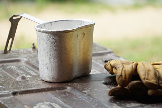 Canteen cup and glove on plate.