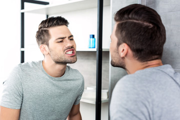 man looking at his teeth